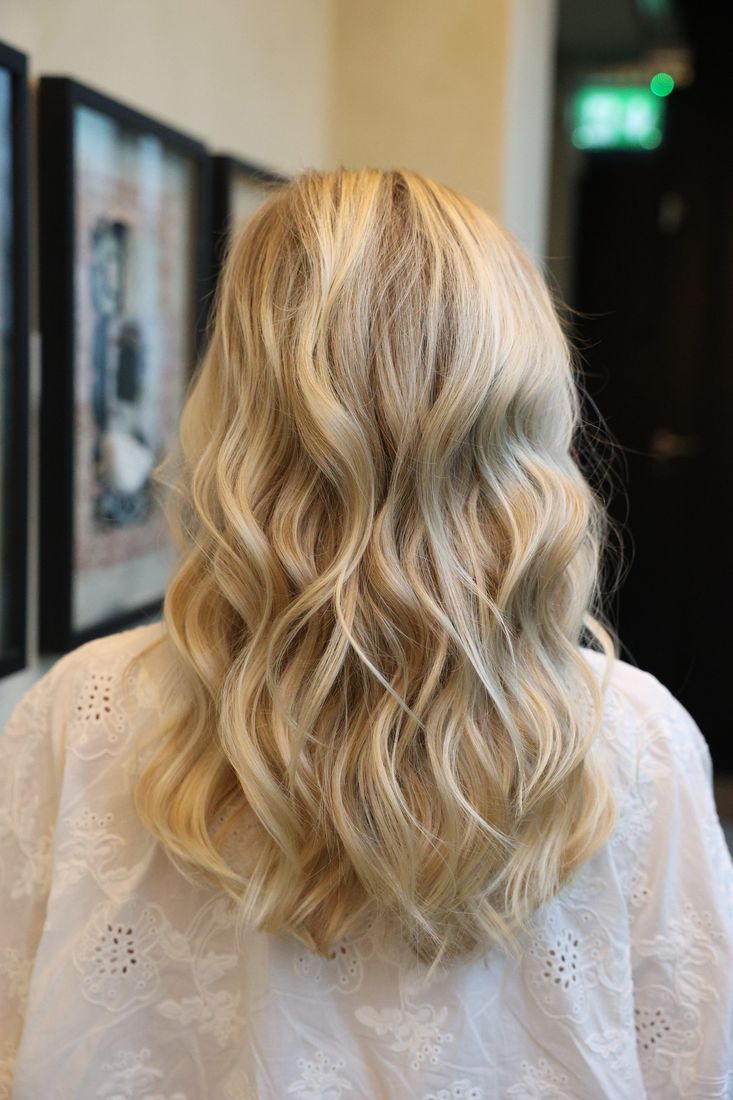 Long blonde waves seen from behind